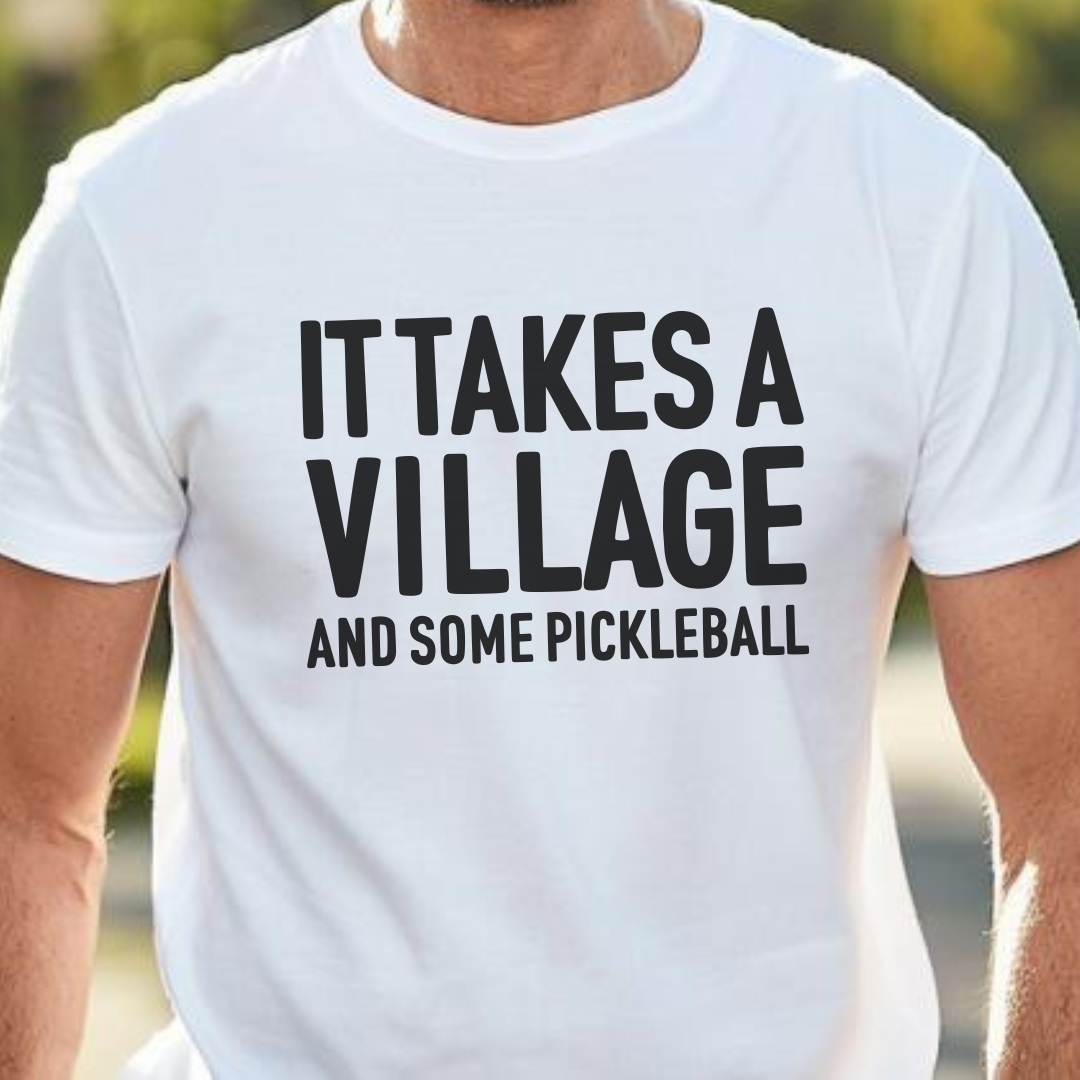 Man_wearing_white_pickleball_tee_it_takes_a_village_and_some_pickleball