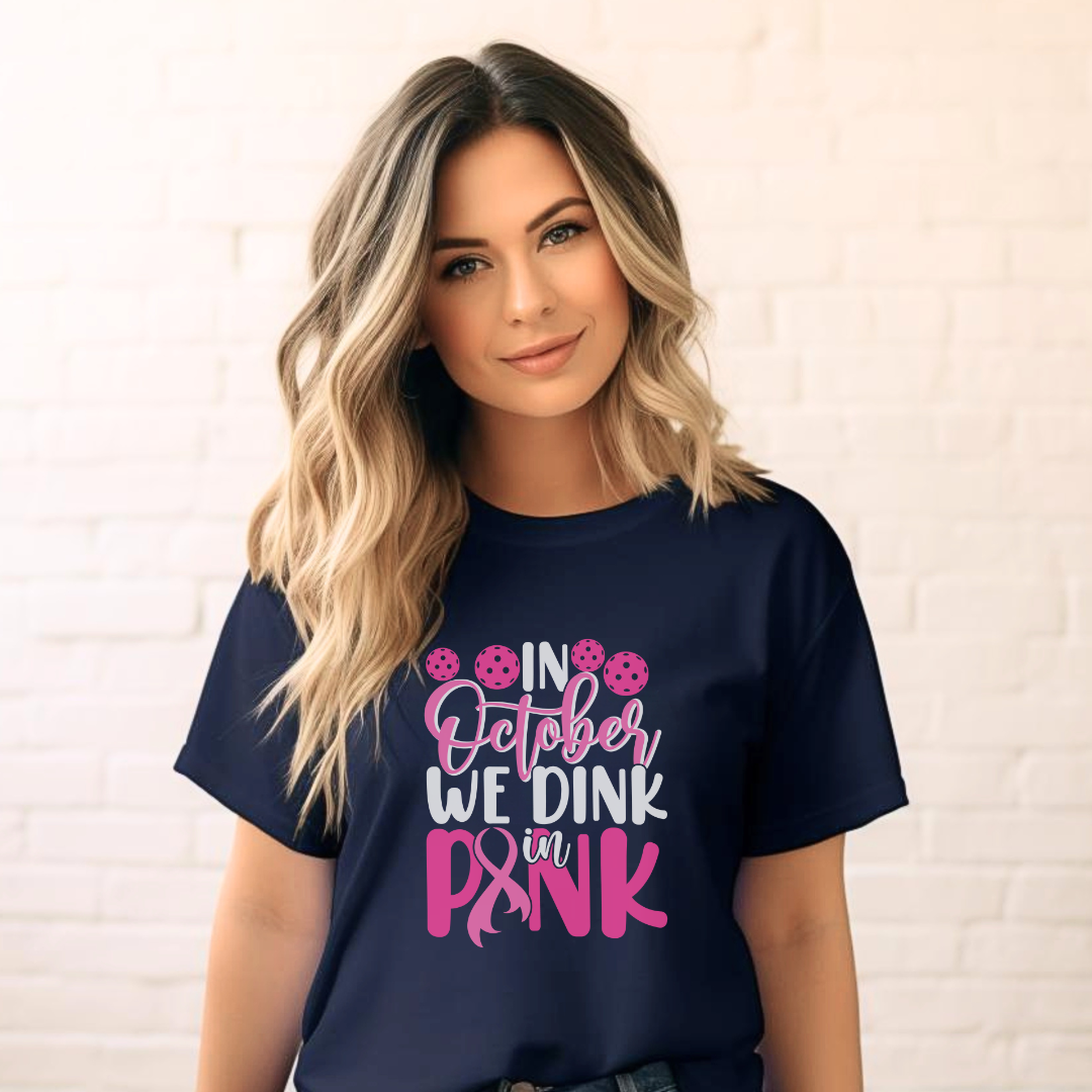 woman wearing a navy blue short sleeve pickleball tee that says in october we dink in pink