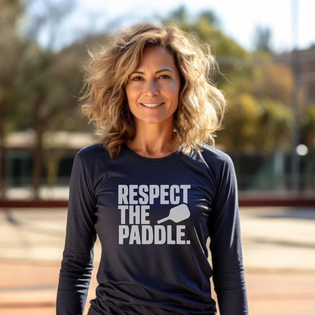 woman wearing navy blue long sleeve pickleball tee that says Respect The Paddle